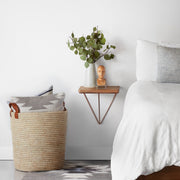 Pillows in handwoven storage basket with handles, natural