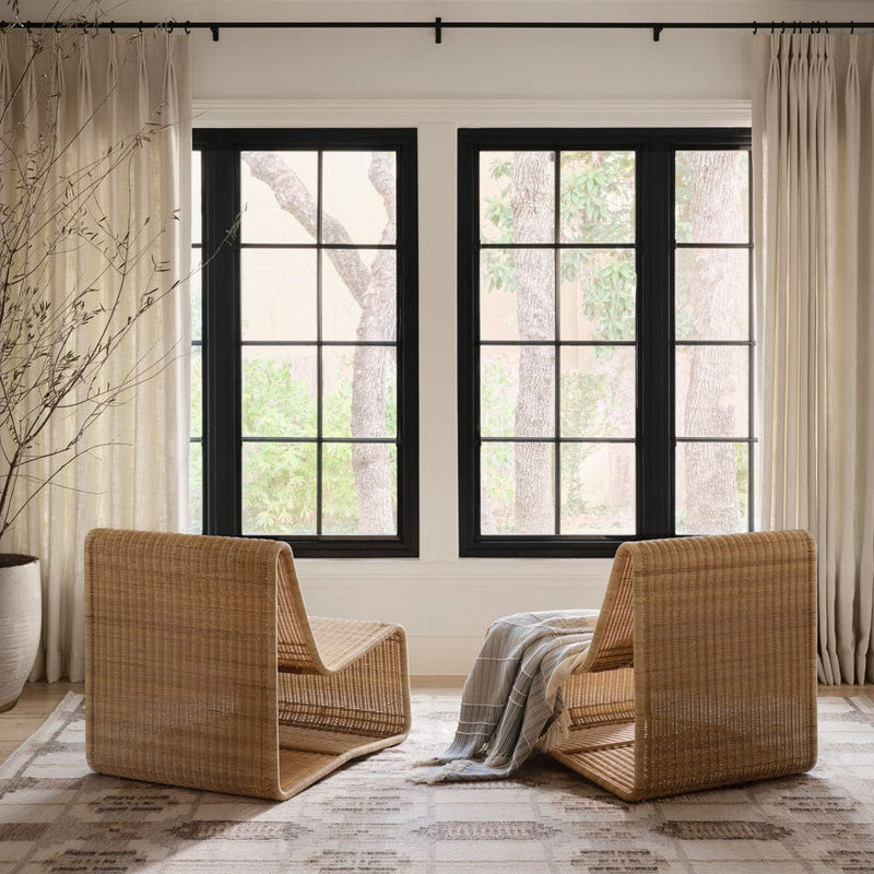 Adah ecru flatweave rug with two modern wicker lounge chairs, ecru