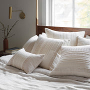 Candelaria Woven Cotton Pillow Styled with Neutral Woven Pillows on Wooden Bed