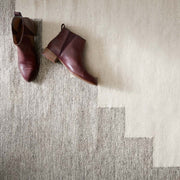 Handwoven Wool Accent Rug in Grey and Cream Styled with Shoes