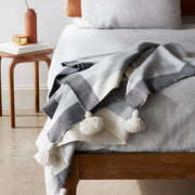Color blocked throw with tassels on bed