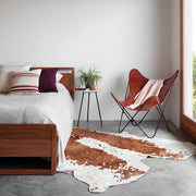 Leather butterfly chair in corner of bedroom, cognac-leather
