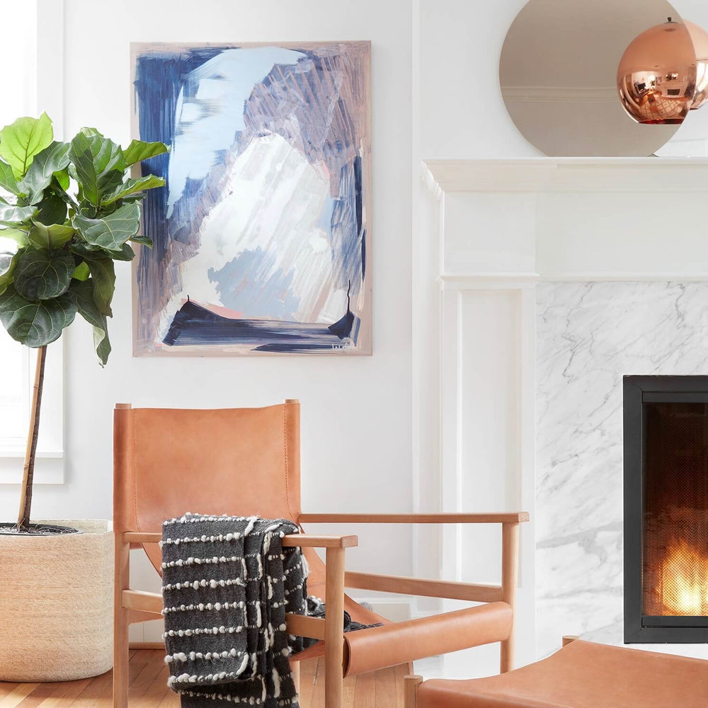 Small circular mirror above fireplace