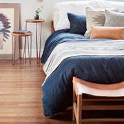 Leather and wood stool at foot of bed