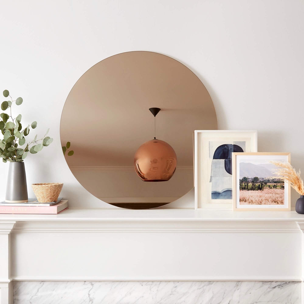 Large circular mirror above fireplace