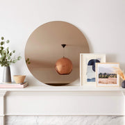 Large circular mirror above fireplace