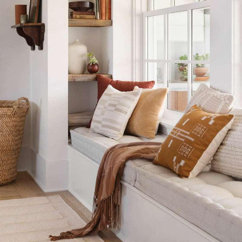 Textured pillows styled on bench, tan
