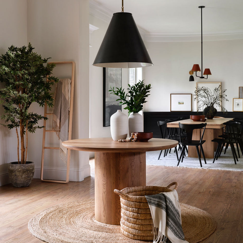 Neutral cream and black throw in basket in front of modern round table.