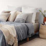 Wool and alpaca and sheepskin pillows styled on bed