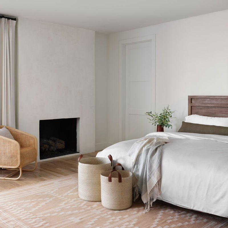Alpaca throw laying on duvet cover with floor baskets at foot of bed, solid-light-grey