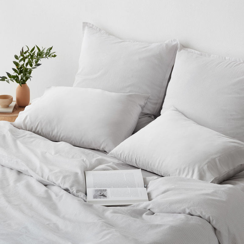 Open book lying on top of duvet, light-grey-stripe