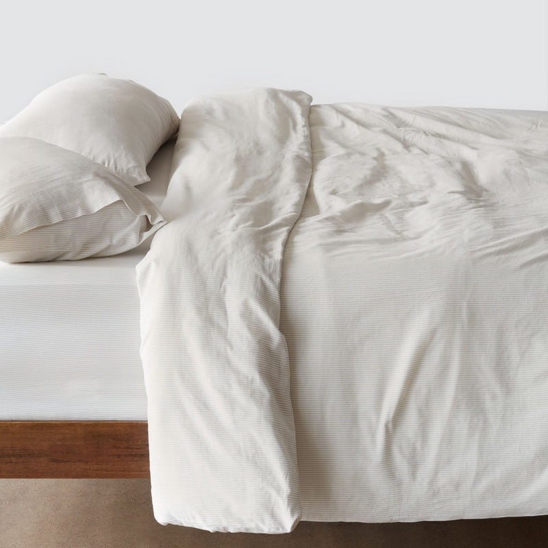 Side of bed with duvet cover and pillows,sand-stripe