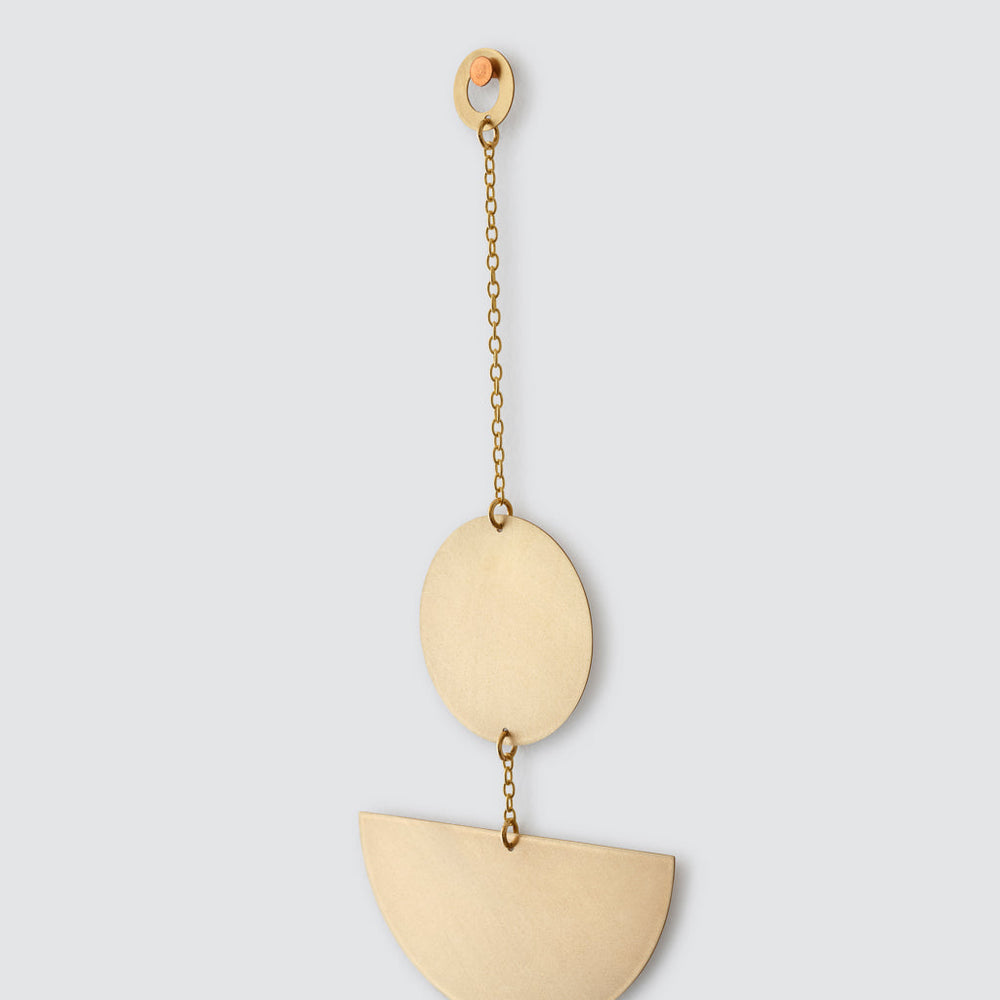 Detailed view of circular hanger for geometric brass wall hanging
