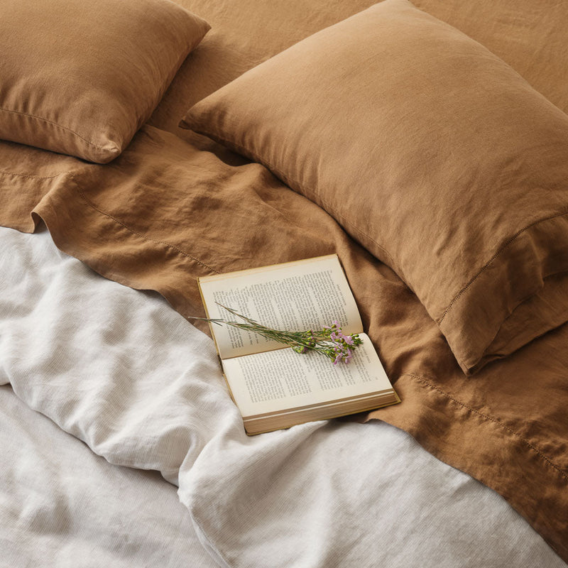 Open book laying on sienna and sand bed, camel