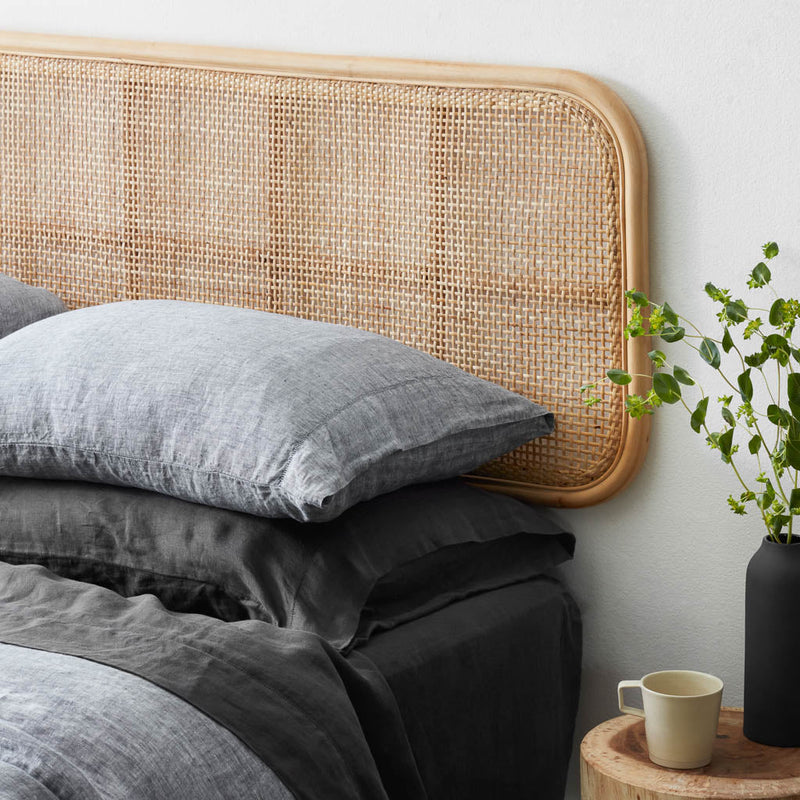 Indigo chambray and charcoal pillows stacked on bed, indigo-chambray