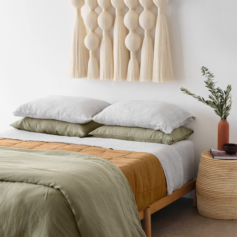 Camel linen quilt on styled bed with cotton wall hanging, camel