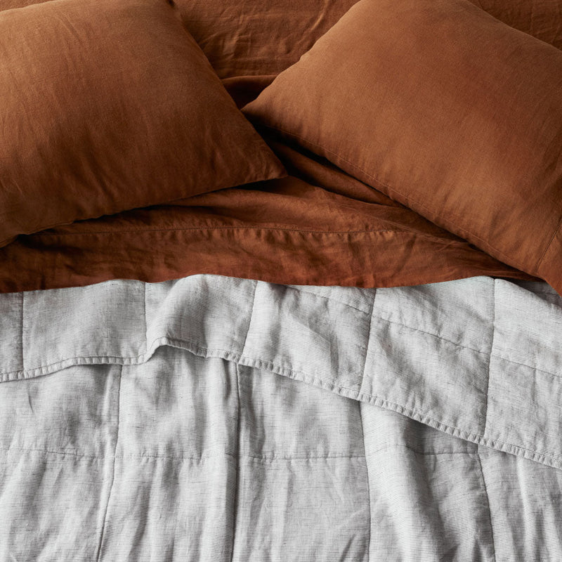 Overhead of Grey Striped linen quilt and sienna sheet set, graphite-stripe