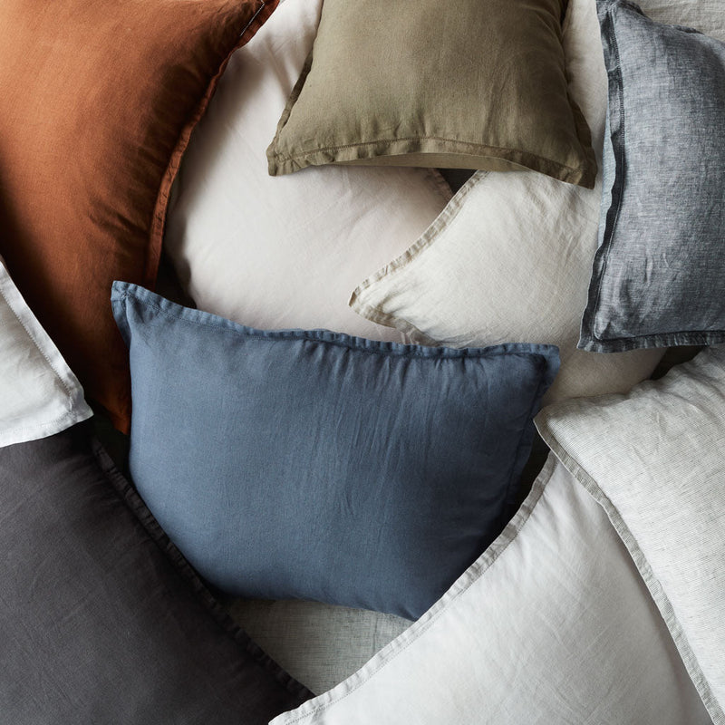 Pile of miscellaneous colored euro shams, indigo-chambray