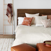 Throw pillows styled on bed, rust