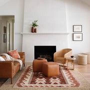 Leather ottomans on patterned area rug, rust