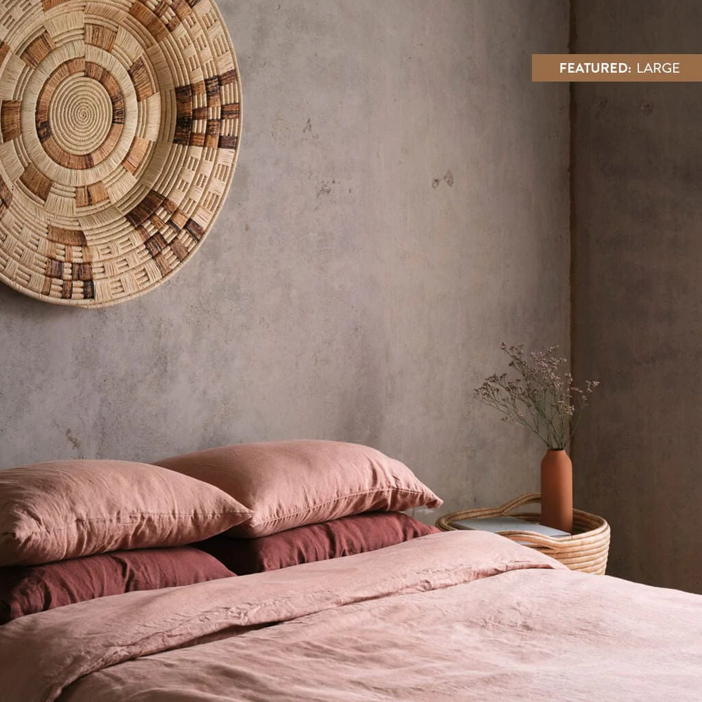Zomba oversized wall hanging above bed with rose linen bedding