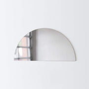 Mirror shaped like half moon hanging on wall, smoke